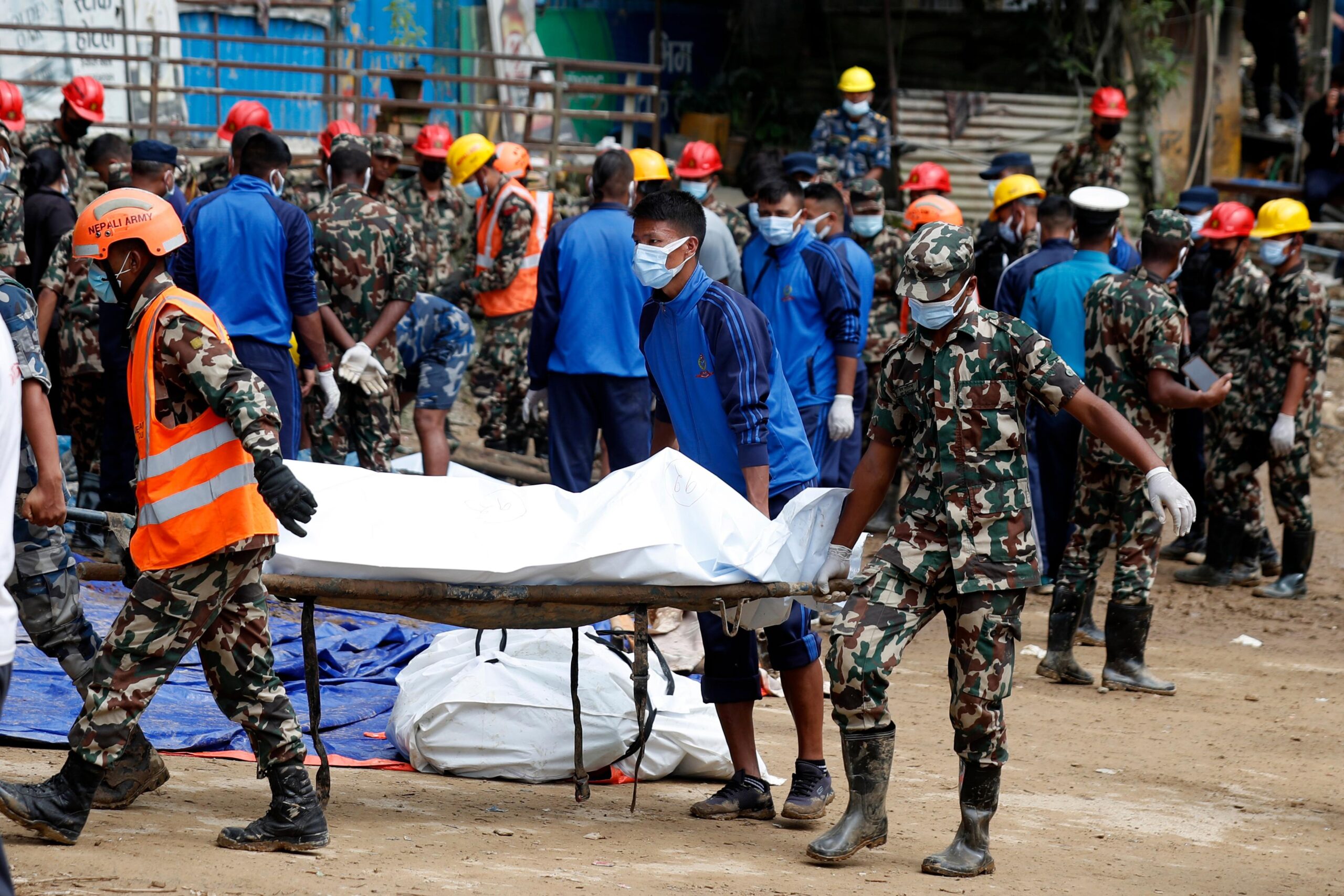 Rescue personnel transport the dead body of a victim who...