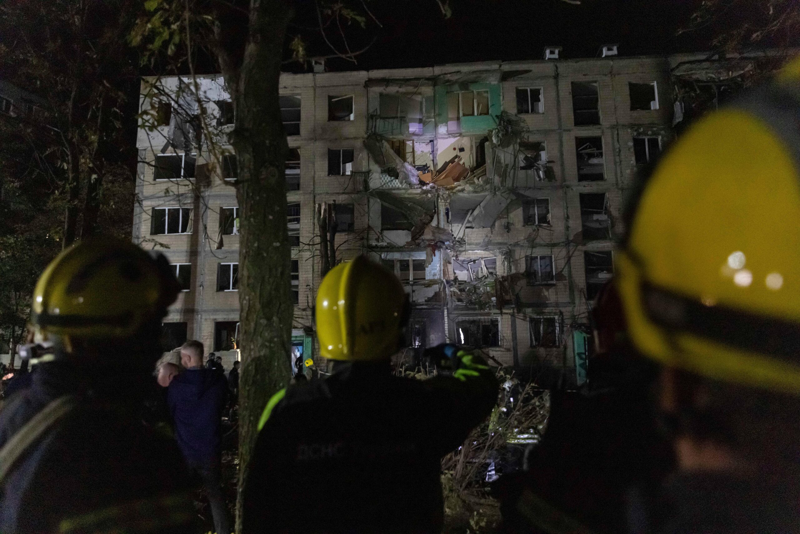 FILE – Firefighters work on a site of a building...