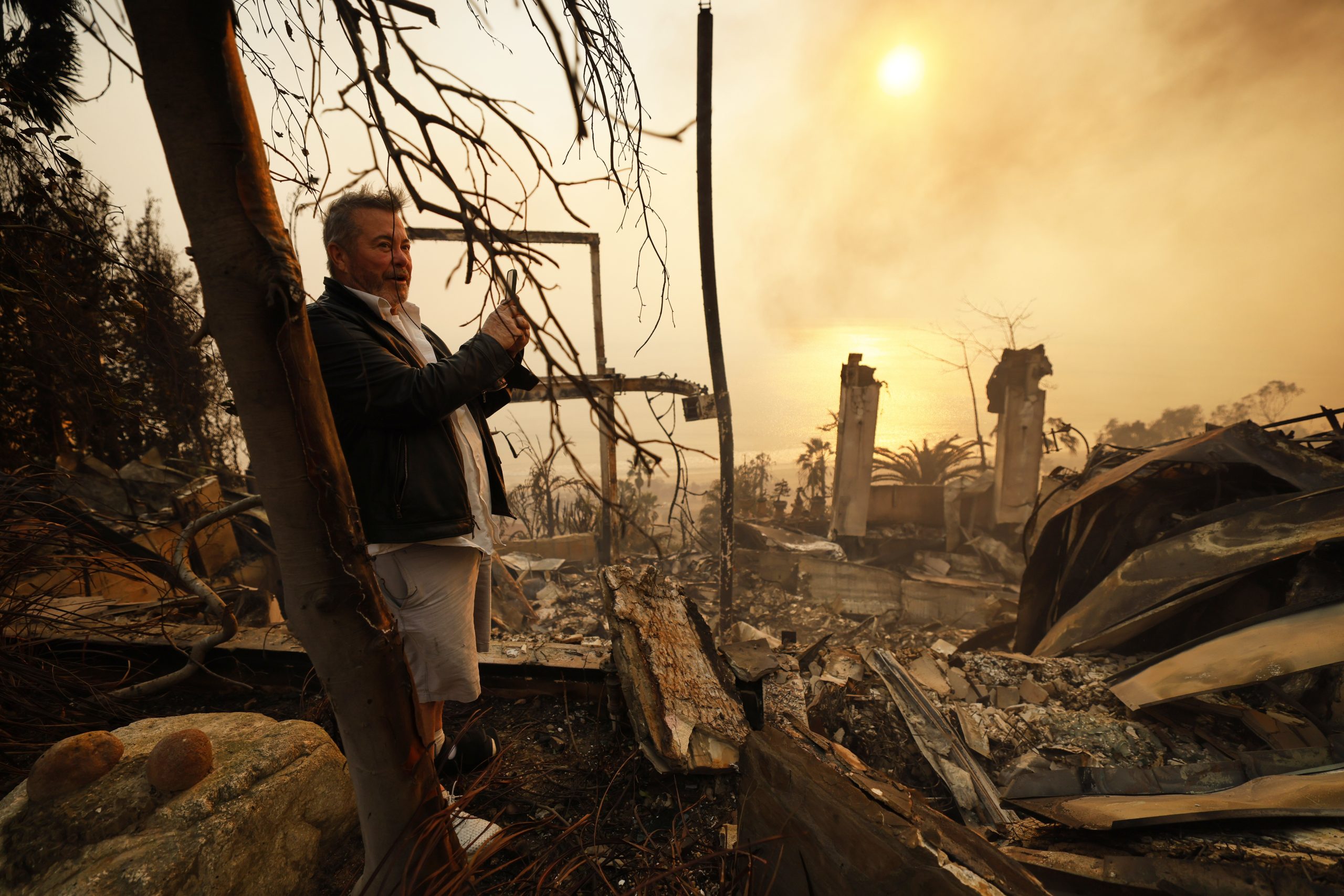 Kelly Kline looks out at his home damaged by the...