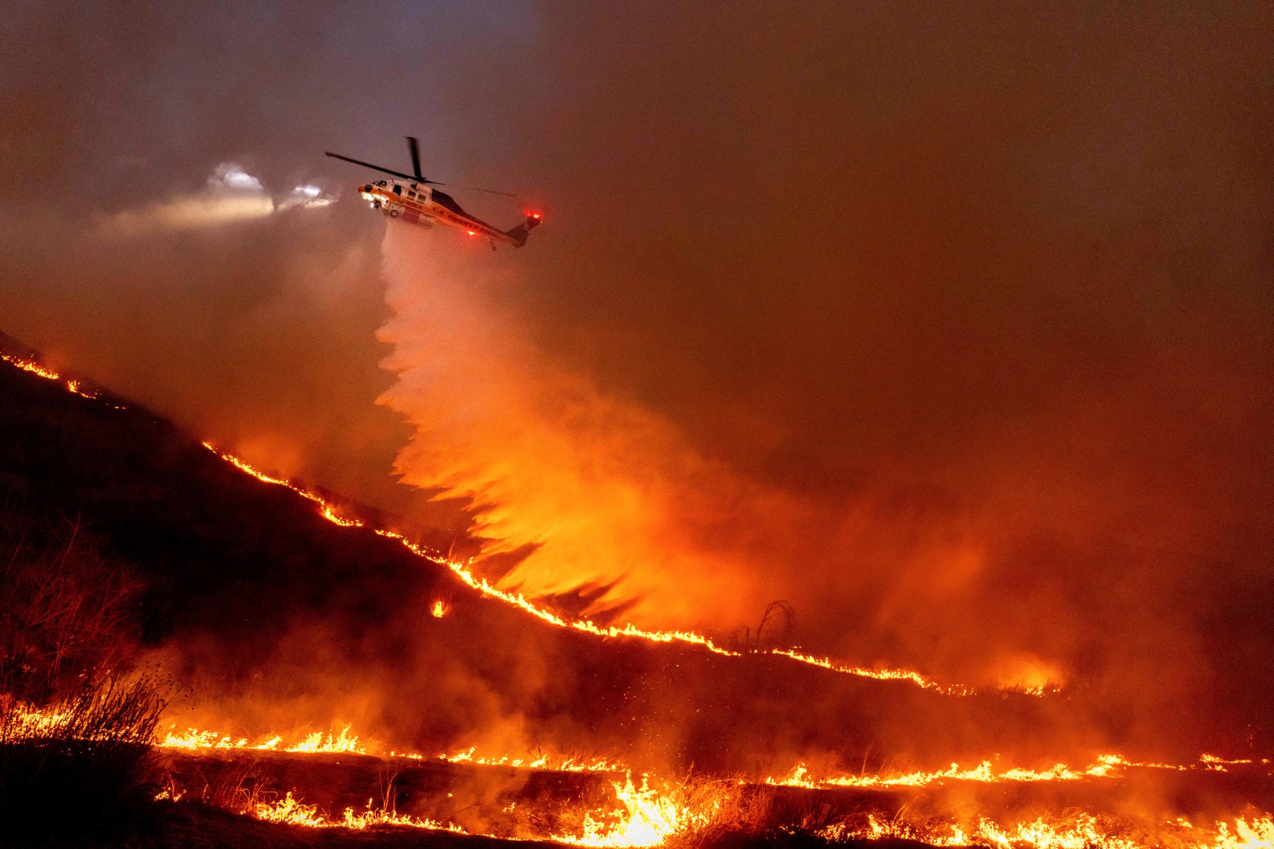 Water is dropped by helicopter on the Kenneth Fire in...