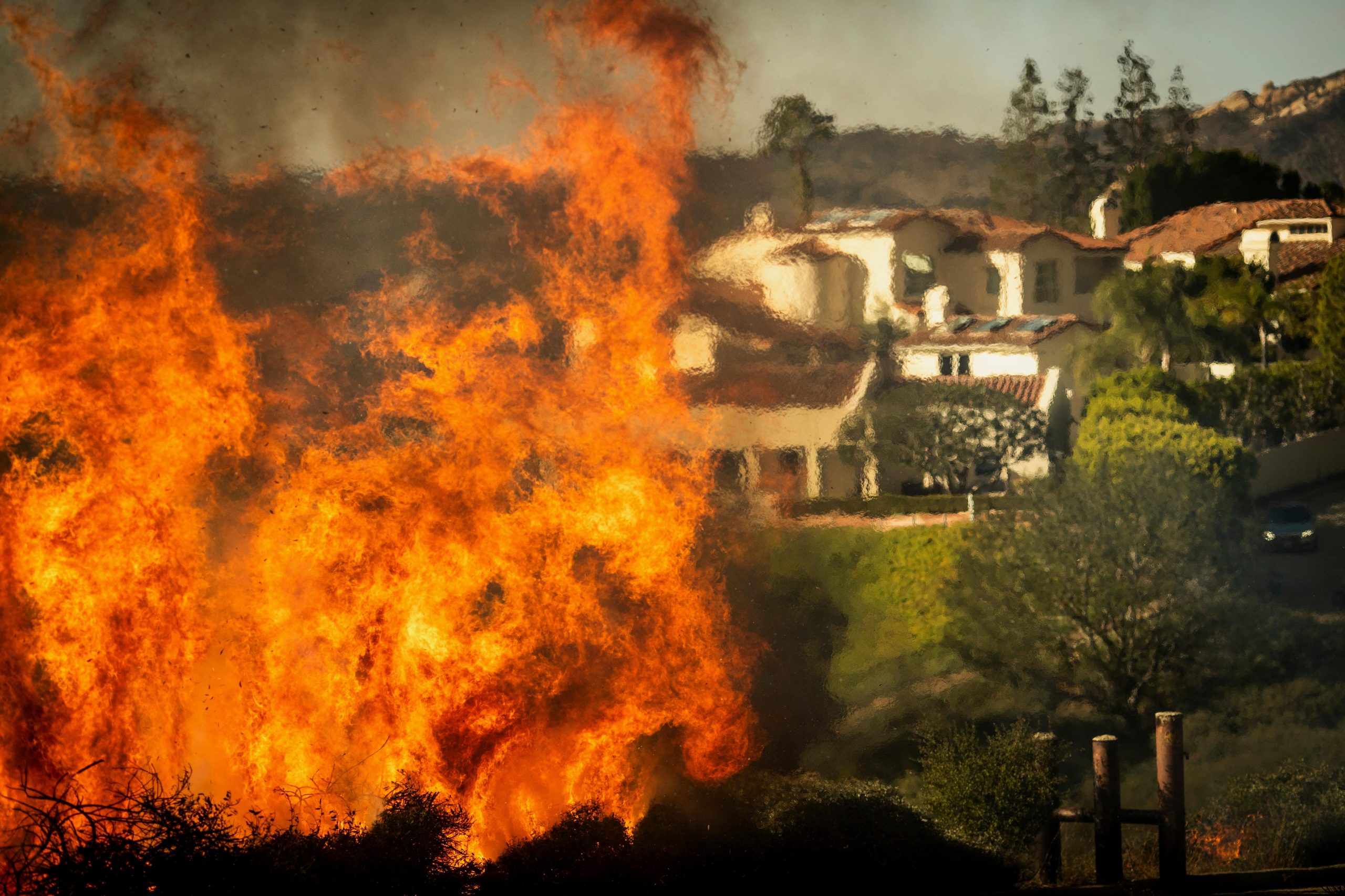 Flames rise as the Palisades Fire advances on homes in...