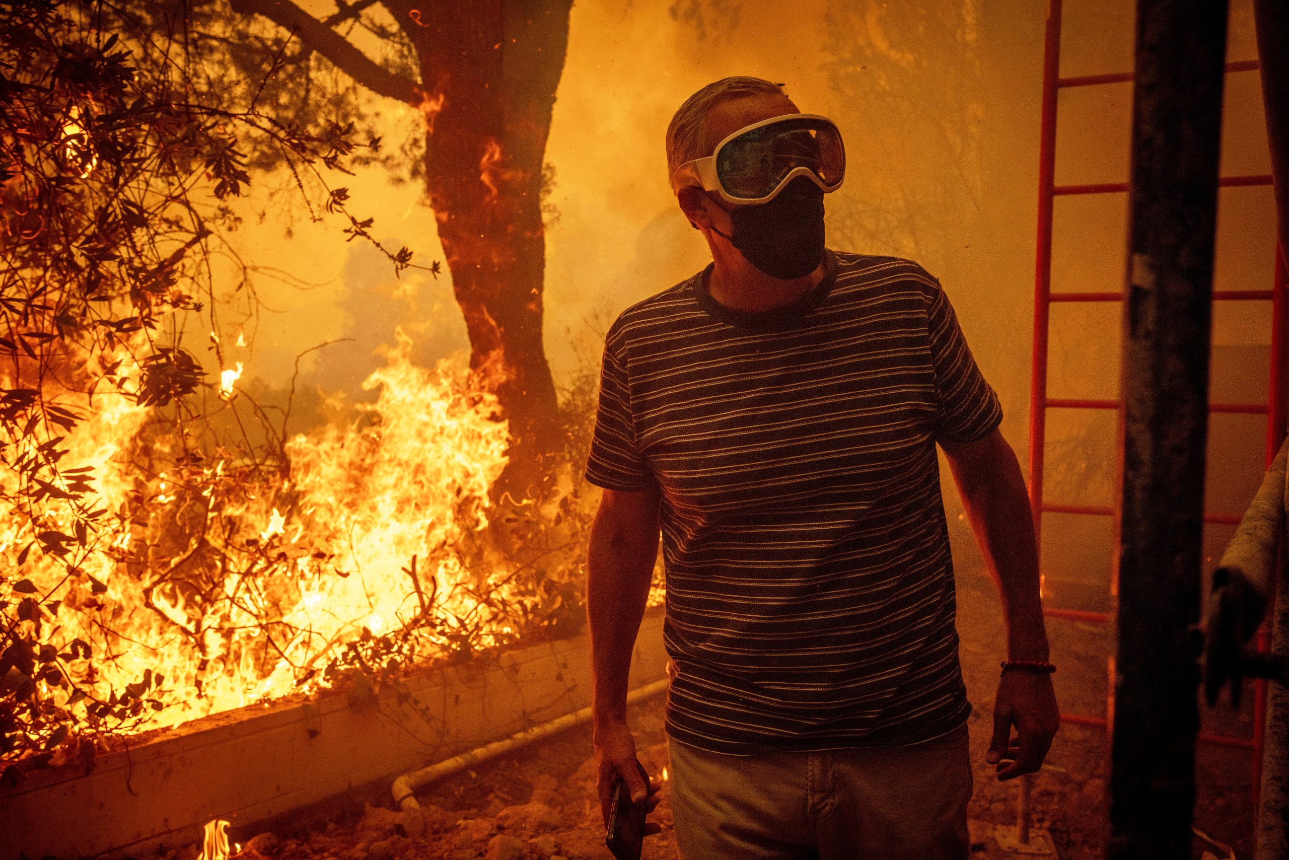 Will Adams watches as flames from the Palisades Fire close...