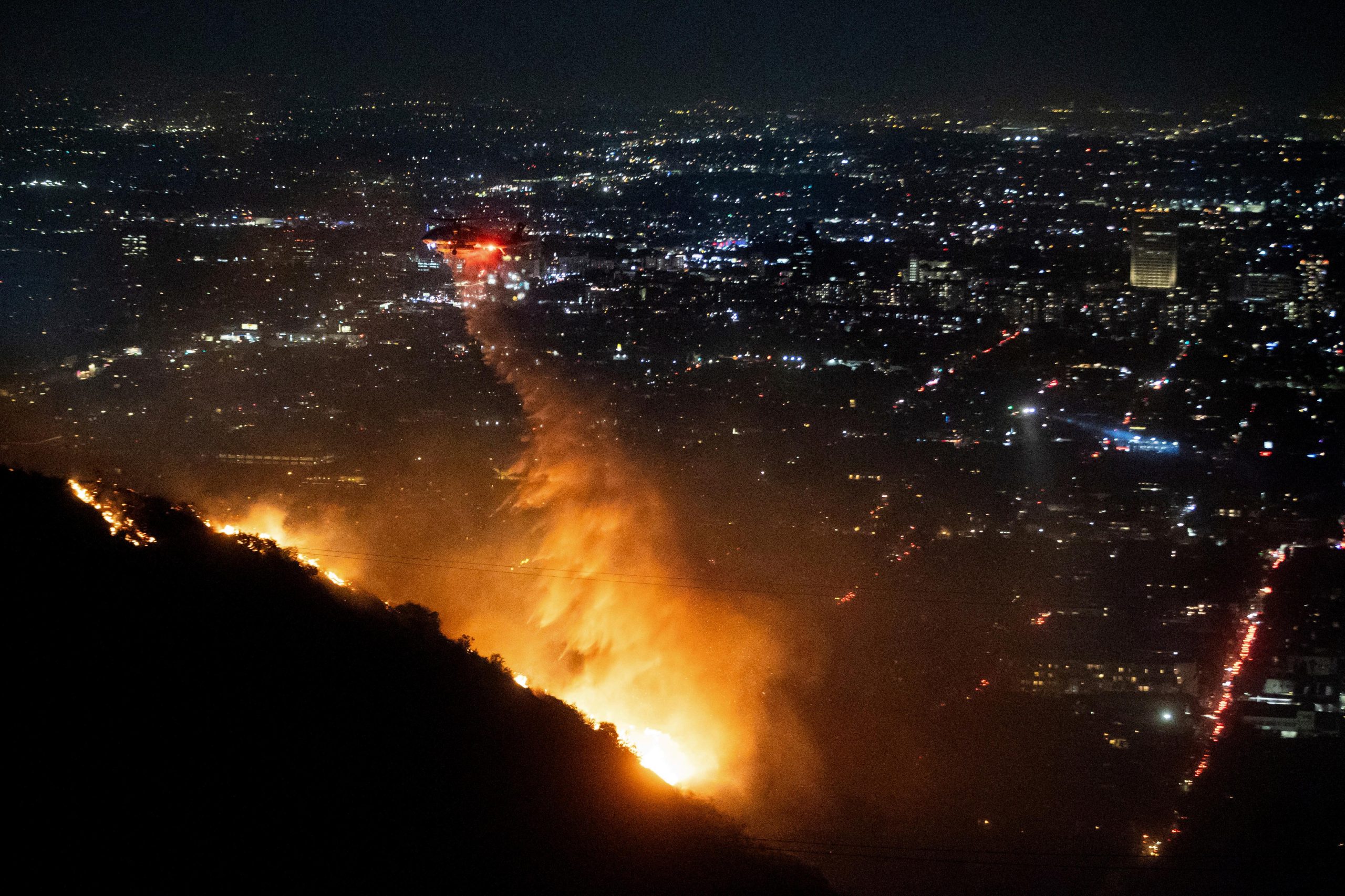 Water is dropped by helicopter on the burning Sunset Fire...