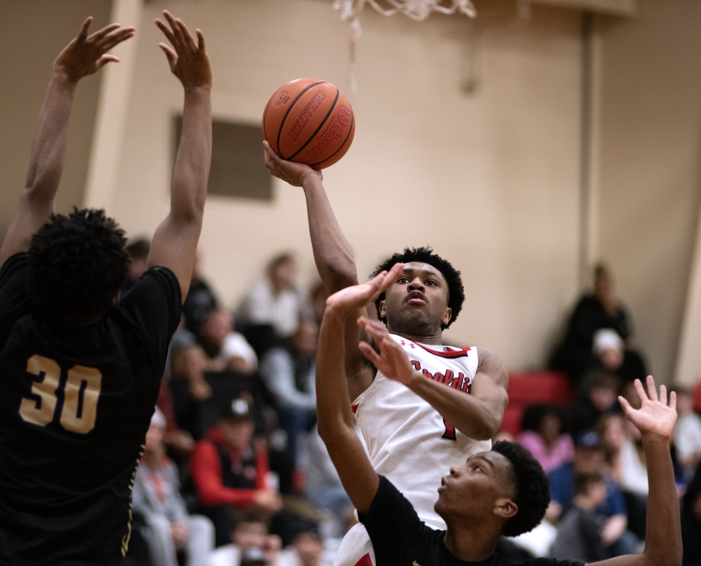 Spalding's T.J. Moultrie shoots against Mount St. Joseph's Brandon Holmes,...