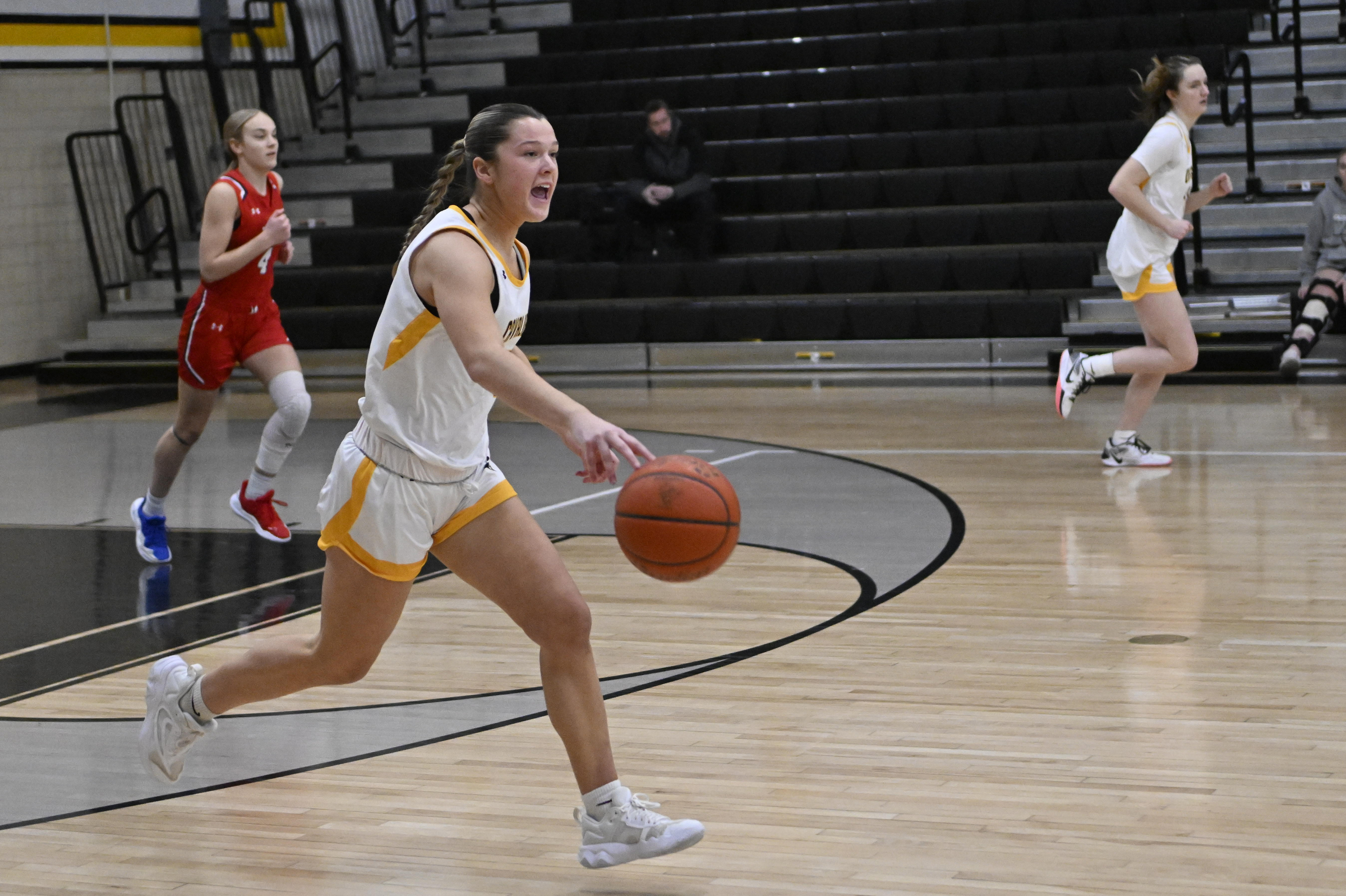 Leah Miller calls out to a teammate as she dribbles...