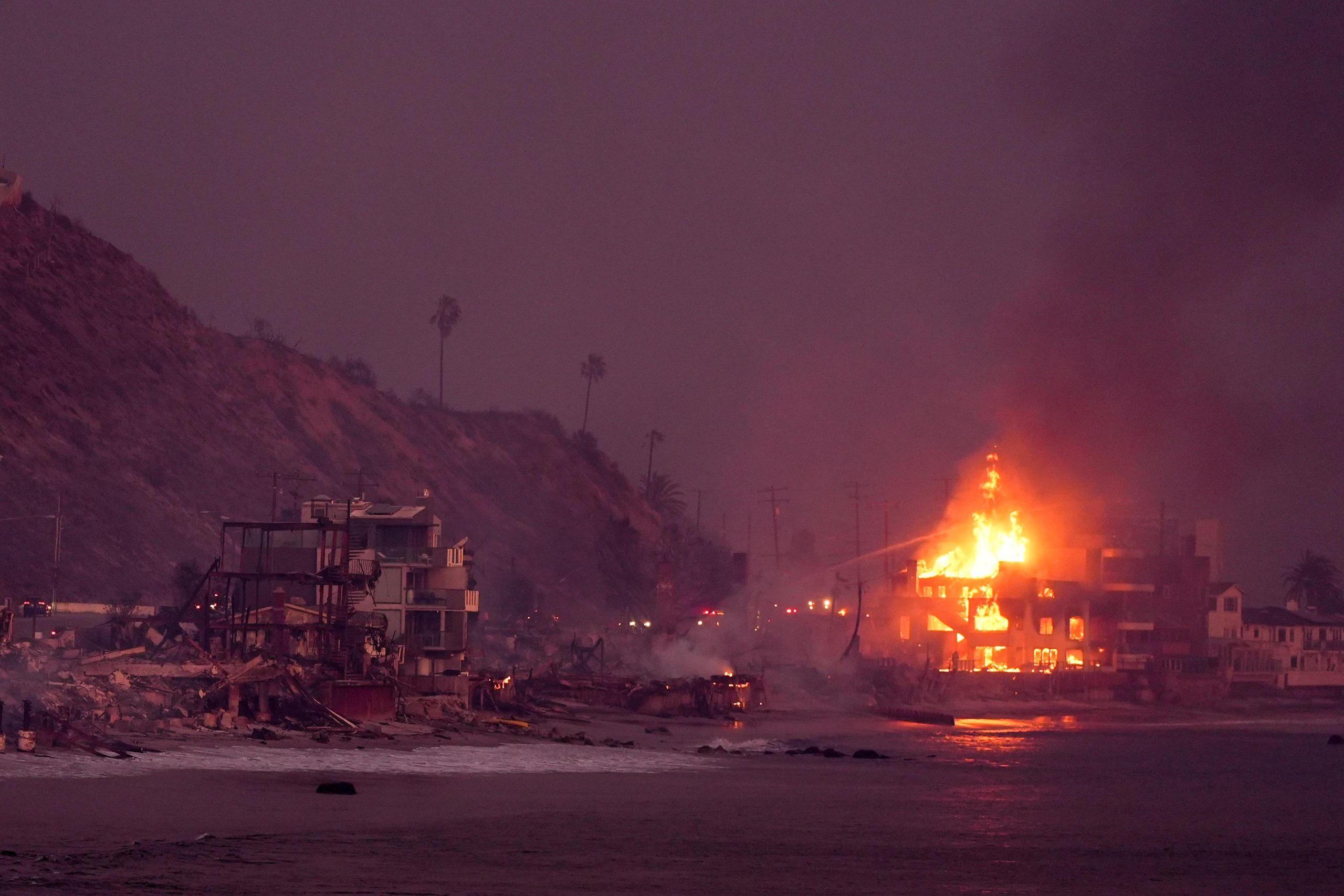 Beach front homes are destroyed by the Palisades Fire Wednesday,...