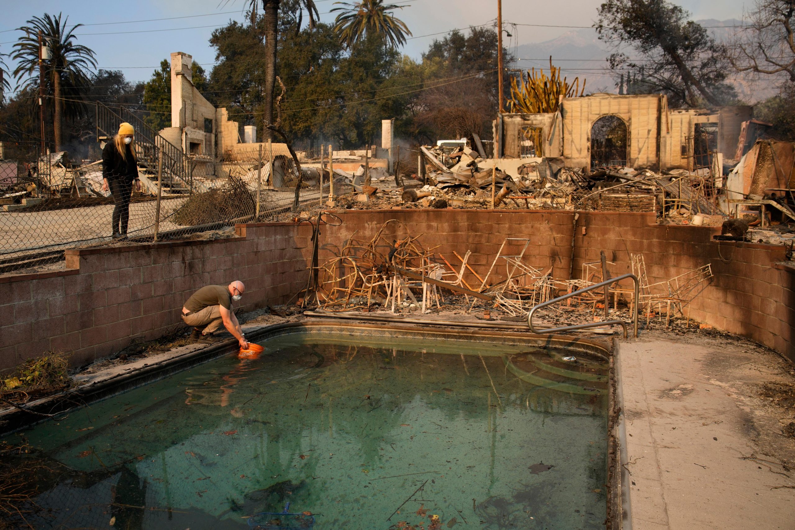 Robert Karban fills a bucket with water from a swimming...