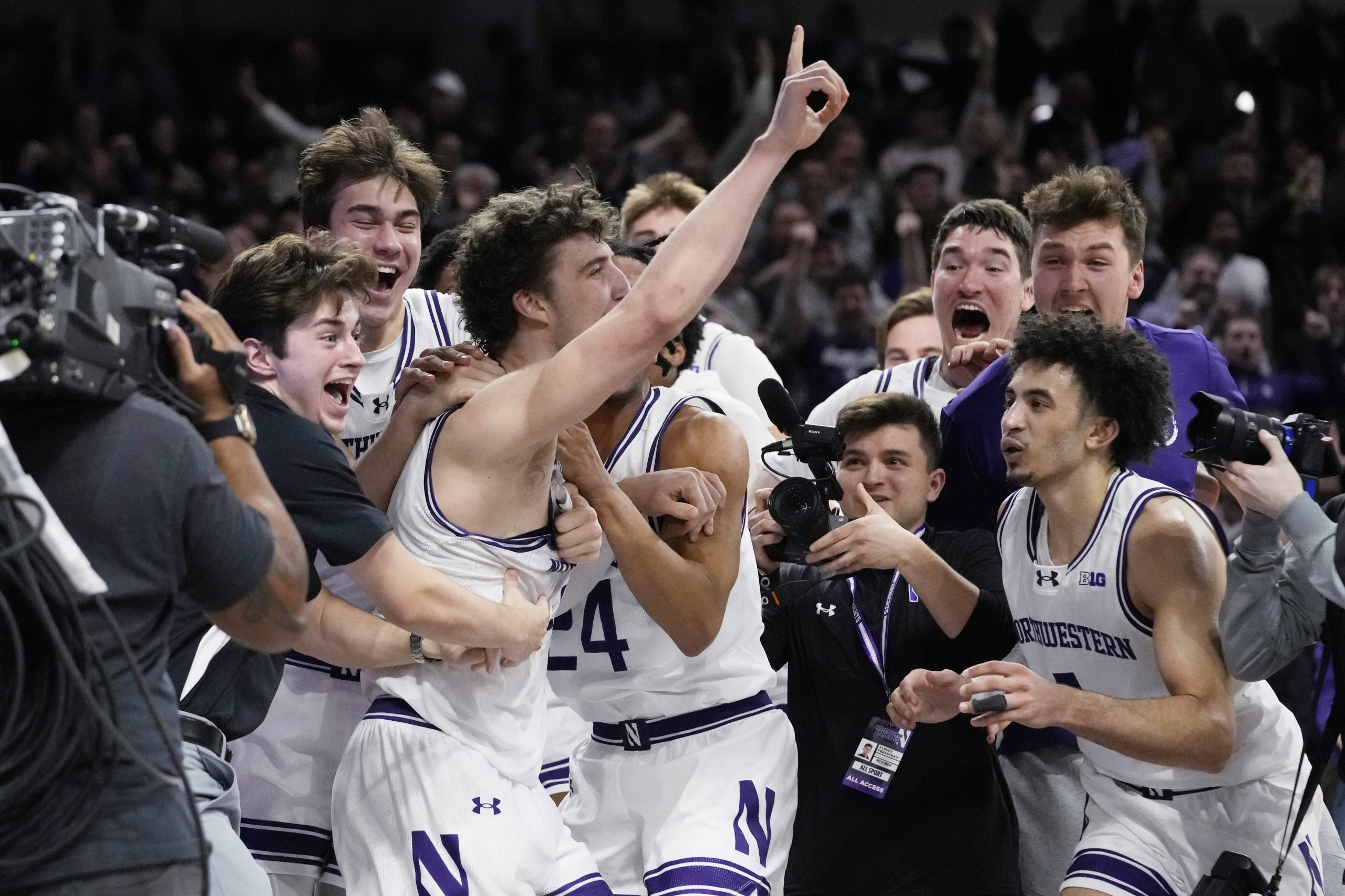 Northwestern forward Nick Martinelli points as he celebrates with teammates...