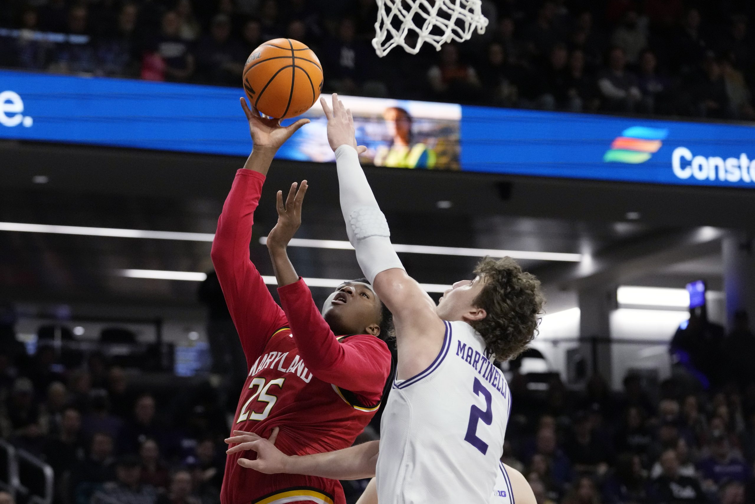 Maryland center Derik Queen, left, looks to shoot over Northwestern...