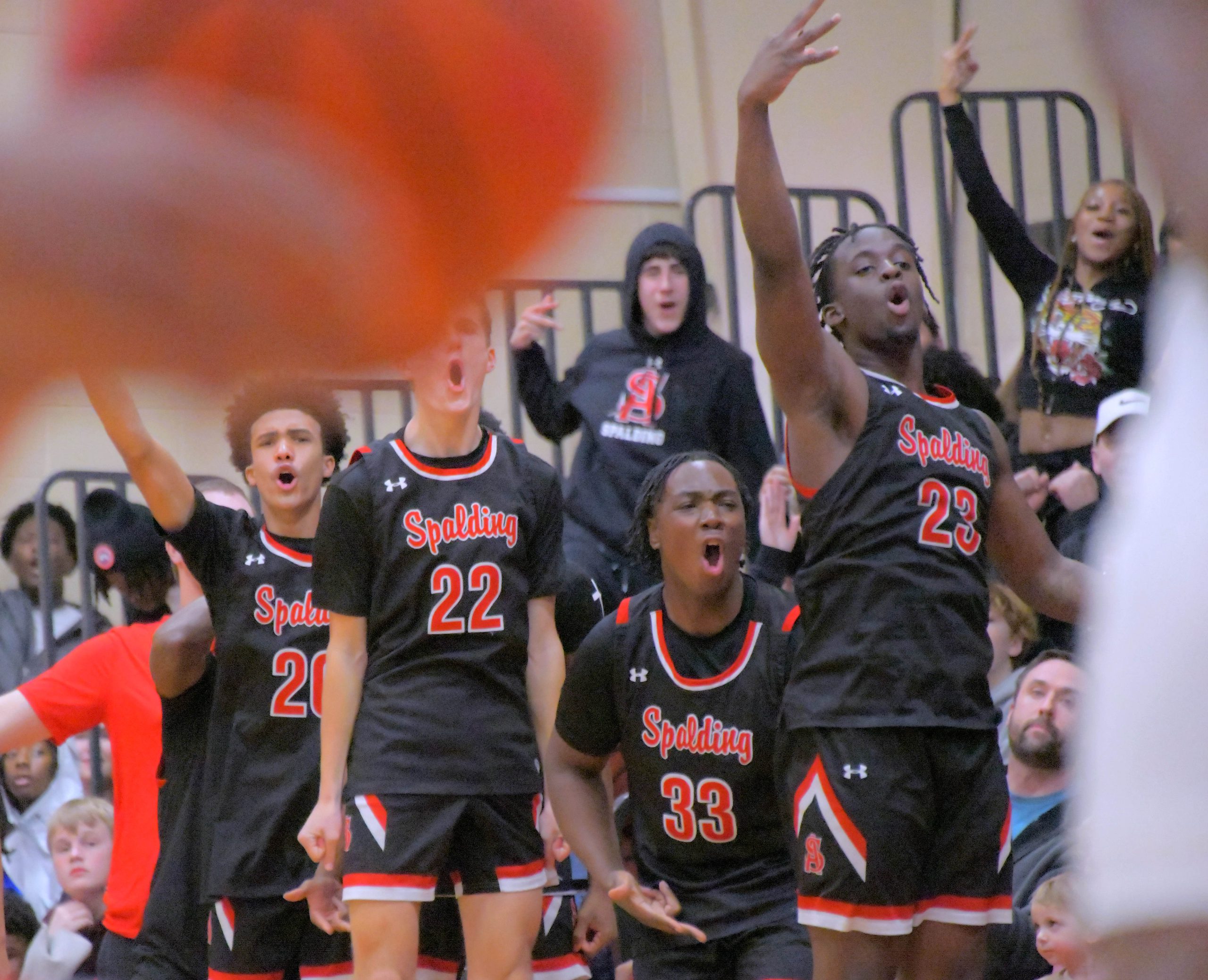 The Archbishop Spalding Cavaliers bench celebrate a three point basket...