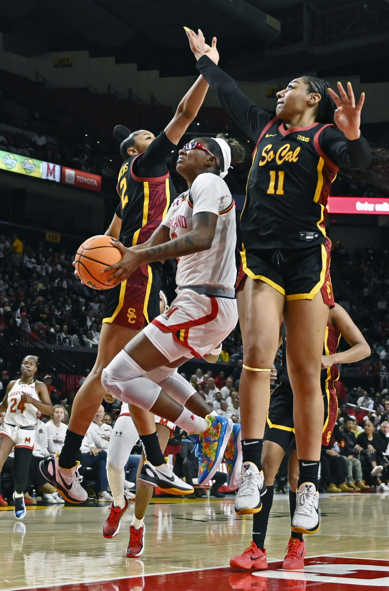 Maryland’s Shyanne Sellers, center, scores a layup against the defense...